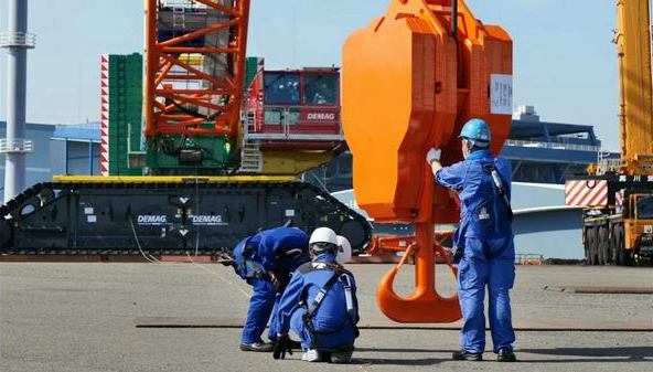 Команда специалистов готовится к монтажу крана